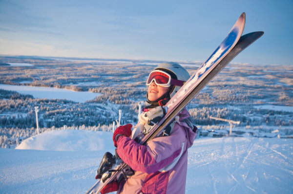 School girl carrying skis