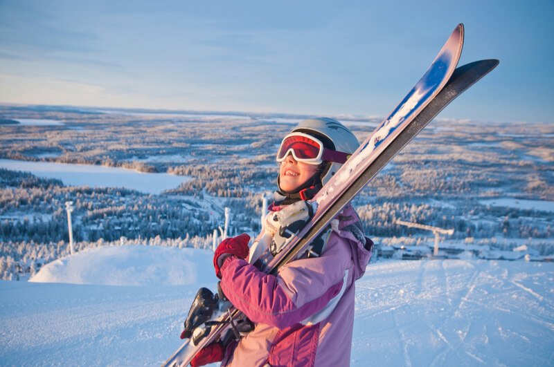 School girl carrying skis School girl carrying skis